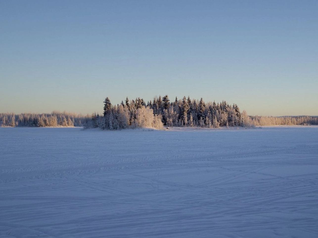 Un lago bajo el hielo al amanecer, antes de que salga el sol